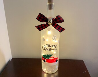 Luz navideña con forma de botella de vino y camión rojo