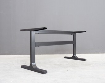 May include: Black metal table base with a two-tiered design. The base has a wide, flat top and two sturdy legs that flare out at the bottom.