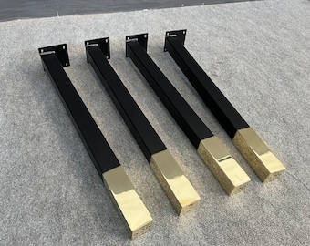 May include: Five black metal table legs with gold accents. The legs are square and have a flat top. The gold accents are on the bottom of the legs.