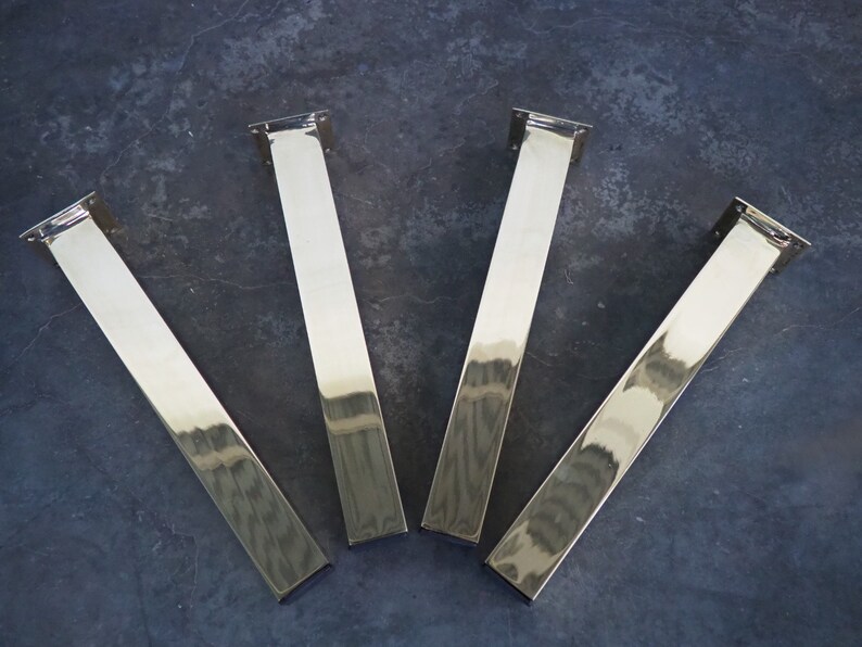 Four silver metal table legs with a rectangular shape and a polished finish.