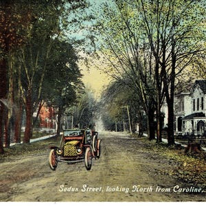 Könnte beinhalten: Vintage Postkarte mit der Sedus Street in Clyde, NY, Blick von Caroline. Das Bild zeigt ein klassisches Auto auf einer von Bäumen gesäumten Straße mit Häusern auf beiden Seiten. Die Postkarte hat einen Sepia-Ton, mit dem Text "Sedus Street, looking North from Caroline, Clyde, N. Y."