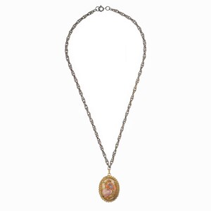 May include: A silver chain necklace with a gold oval pendant featuring a pink and white cameo image.