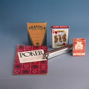 May include: A collection of vintage items including a box of Crayola crayons, a deck of playing cards with a King of Hearts, a harmonica, a small box of Tom Thumb Junior Playing Cards, and a poker book. The poker book has the text "POKER" on the cover.