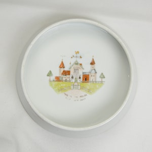 May include: White ceramic bowl with a hand-painted design of a house with a weathervane and the text "This is the house that Jack built".
