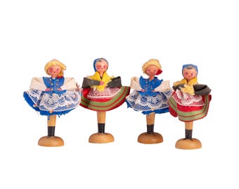 Zestaw czterech miniaturowych, ręcznie wykonanych, drewnianych lalek na kołki w stylu ludowym