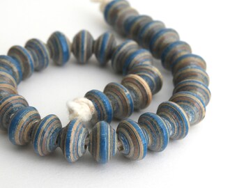 May include: A strand of blue and brown paper beads. The beads are layered and have a spiral pattern.