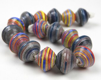 May include: A colorful necklace made of paper beads. The beads are layered in shades of blue, red, yellow, and white. The necklace is a unique and handmade piece of jewelry.