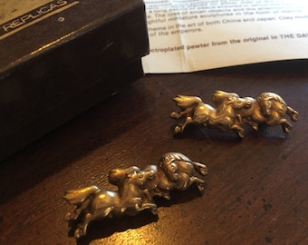 Puede incluir: Dos esculturas de metal dorado de caballos corriendo. Las esculturas son de peltre plateado, reproducidas a partir del original del Dayton Art Institute, 1976 Alva.