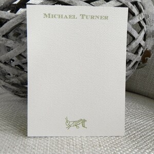 May include: A white card with a green grasshopper illustration and the name "MICHAEL TURNER" printed in green at the top.