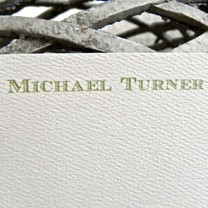 May include: A white card with the name "MICHAEL TURNER" printed in green letters.