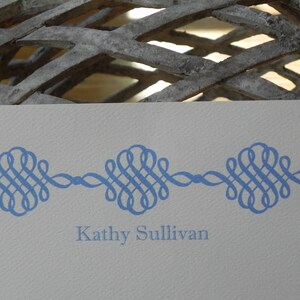 Peut inclure: Une carte blanche avec une bordure d&eacute;corative bleue et le texte "Kathy Sullivan" imprim&eacute; en bleu.
