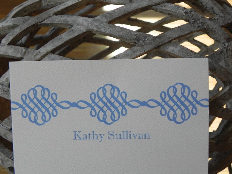 Peut inclure: Une carte blanche avec une bordure d&eacute;corative bleue et le texte "Kathy Sullivan" imprim&eacute; en bleu.