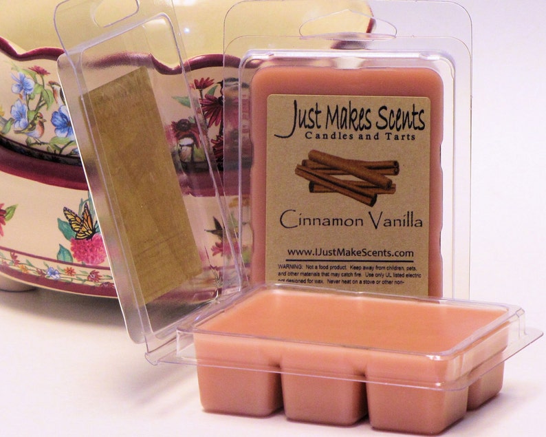 May include: A clear plastic container with a pink wax melt inside. The wax melt is labeled "Cinnamon Vanilla" and is from the company "Just Makes Scents Candles and Tarts".