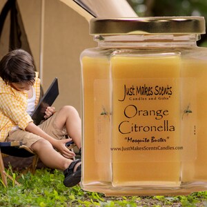 May include: A glass jar candle with a gold lid and a yellow label. The label reads "Just Makes Scents Candles and Gifts", "Orange Citronella", "Mosquito Buster", and "www.JustMakesScentsCandles.com".