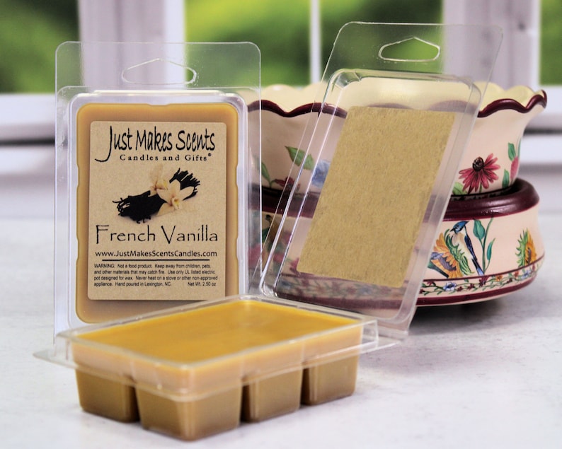 May include: A clear plastic package containing a wax melt with a brown label that reads "Just Makes Scents Candles and Gifts" and "French Vanilla". The label also includes the website address "www.JustMakesScentsCandles.com".