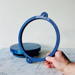 May include: A blue plastic ring with the text "South Fork Studio Bat Adapter BW22" printed on it. The ring is designed to be used with a pottery wheel.