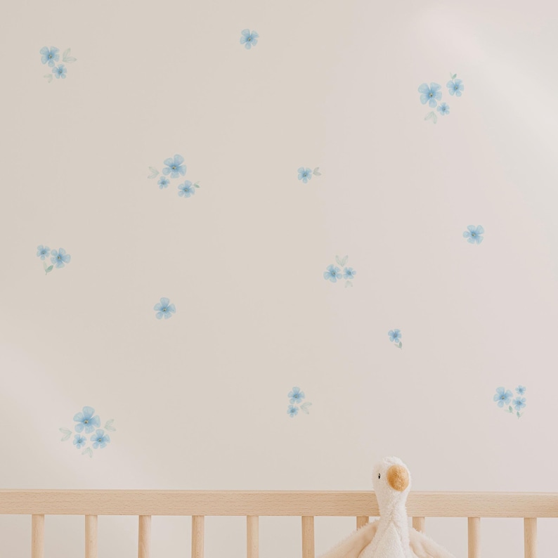 Pared blanca de dormitorio infantil decorada con vinilos decorativos y adhesivos de alta calidad en forma de flores en color azul. Vinilo de alta calidad - Nicolasito.es
White wall of a kids bedroom decorated with high-quality decorative adhesive vinyl stickers in the shape of blue flowers. Premium vinyl – Nicolasito.es