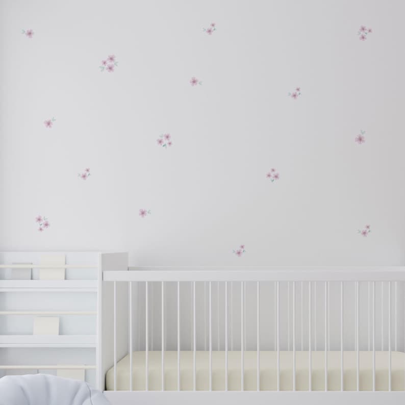 Vinilo decorativo de pared en forma de flores silvestres en color lila sobre pared blanca de dormitorio de bebé con muebles en blanco - Nicolasito.es
Decorative wall vinyl with lilac wildflower design on a white nursery wall with white furniture. Easy to apply and remove without leaving marks, creating a wallpaper effect – Nicolasito.es