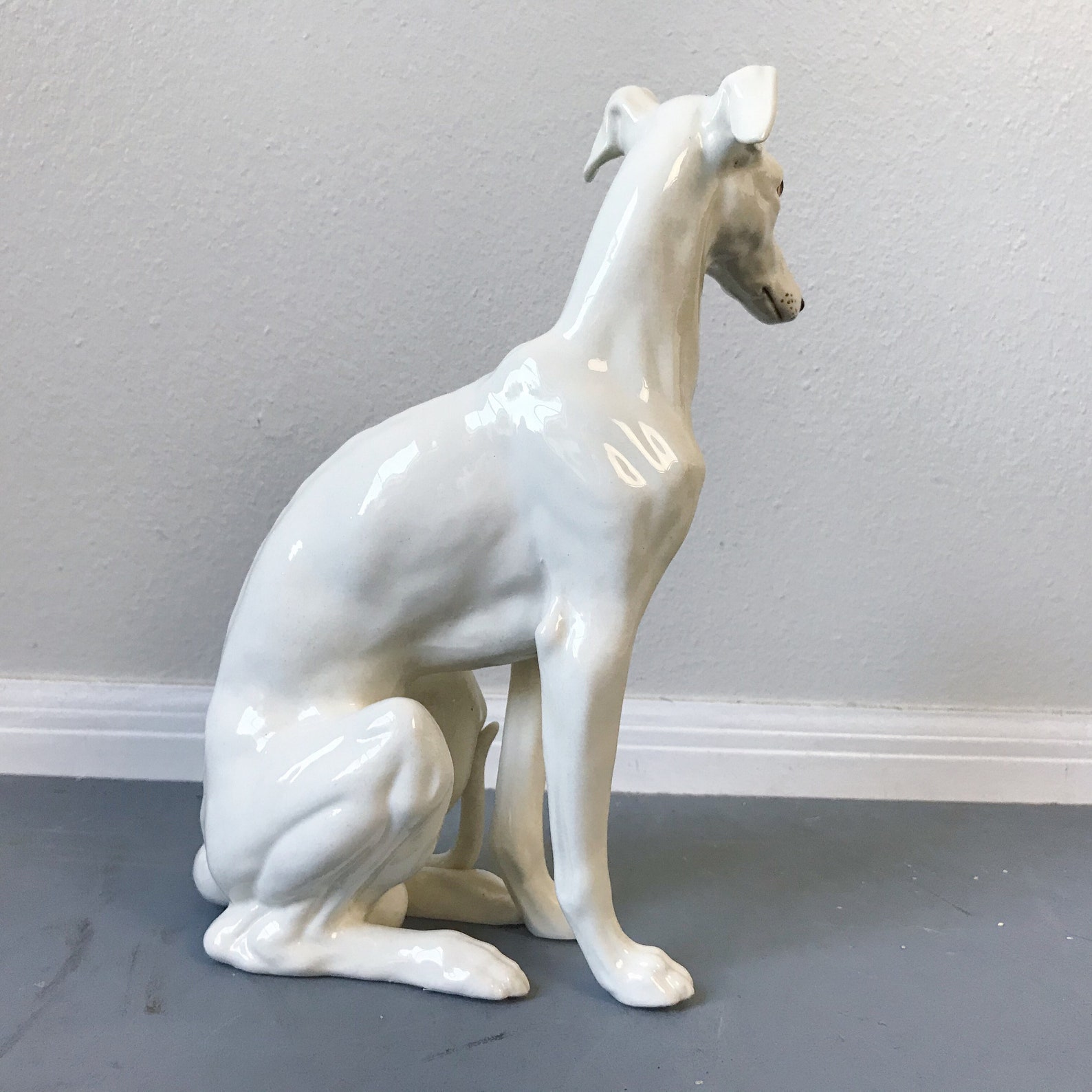 white ceramic greyhound statue