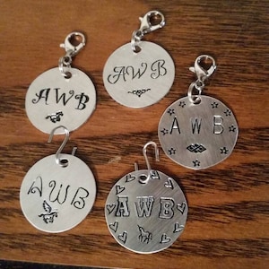 May include: Five silver metal keychains with the initials "AWB" engraved on each. Each keychain has a different design, including a horse, hearts, stars, and a simple script font.