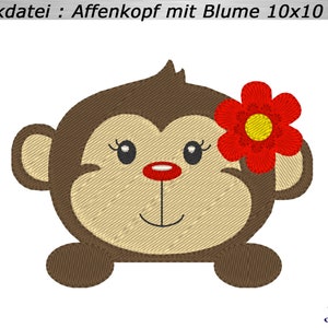 May include: Embroidered design of a cartoon monkey head with a red flower. The monkey has brown fur, a tan face, and a red nose. The text "Stickdatei : Affenkopf mit Blume 10x10" is at the top.