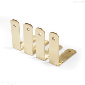 May include: Five gold metal corner brackets with a hole in the center of each bracket.