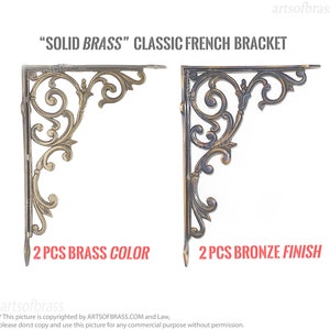 Op de afbeelding: "SOLID BRASS" Klassieke Franse beugels in messing en bronzen afwerkingen. De beugels hebben sierlijke, opgerolde ontwerpen. De afbeelding toont twee sets beugels, één in messingkleur en de andere in een bronzen afwerking.