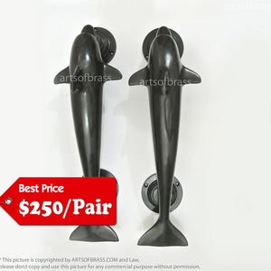 Könnte beinhalten: Ein Paar schwarze Delfin-Türgriffe mit einem Preisschild, auf dem "Best Price 250 € pro Paar" steht.