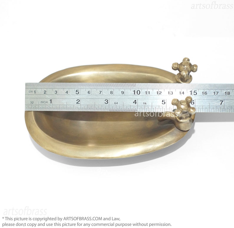 May include: A small, oval-shaped brass bathtub with a faucet on each end. The bathtub is 15 inches long and is made of solid brass.