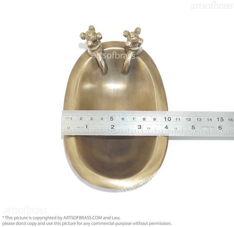 May include: A small, brass bathtub with two faucets. The bathtub is about 2 inches long and is made of solid brass. It is a decorative item and would be a great addition to any bathroom.