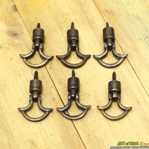May include: Six antique brass drawer pulls with a unique curved design. Each pull has a screw on the back for easy installation.