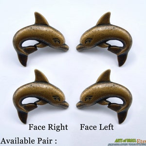 Puede incluir: Conjunto de cuatro tiradores de cajón de delfín de latón antiguo. Cada tirador presenta un diseño de delfín detallado con una cara mirando hacia la derecha o hacia la izquierda. Los tiradores están disponibles en pares.