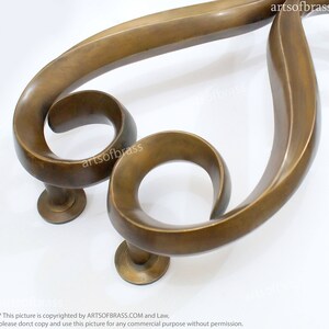 May include: A pair of ornate brass door handles with a unique, swirling design. The handles are made of solid brass and have a polished finish.