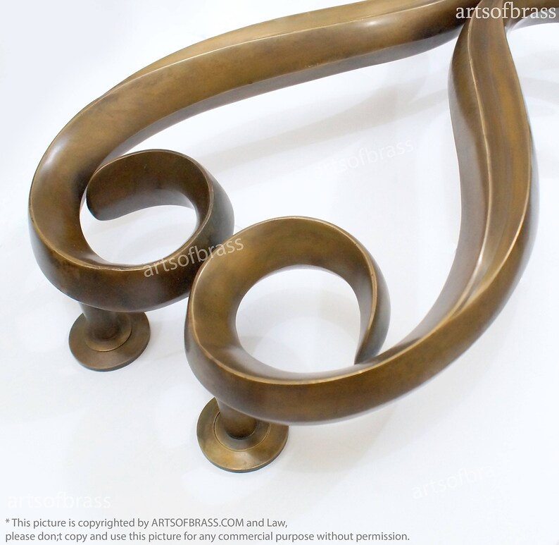May include: A pair of ornate brass door handles with a unique, swirling design. The handles are made of solid brass and have a polished finish.