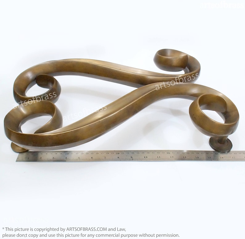 May include: A pair of ornate brass door handles with a swirling design. The handles are approximately 17 inches long.