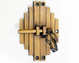 Peut inclure: Un loquet de porte en laiton avec un design Art Déco décoratif. Le loquet a un pêne coulissant et une chaîne avec une clé.