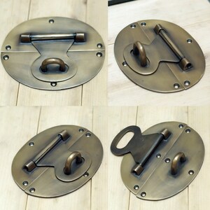 May include: Four antique brass oval-shaped box clasps with a hinged design. Each clasp has a different style of latch and a decorative ring.