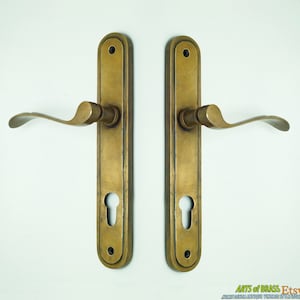 Könnte beinhalten: Ein Paar antike Messing-Türgriffe mit einem Schlüsselloch und einem gebogenen Hebel. Die Griffe sind in ausgezeichnetem Zustand und haben eine schöne Patina.