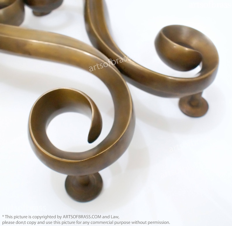 May include: A pair of ornate brass door handles with a swirling design. The handles are made of solid brass and have a polished finish.
