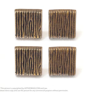 Puede incluir: Cuatro pomos cuadrados de latón para armario con un patrón de veta de madera. Los pomos son de color dorado cálido.