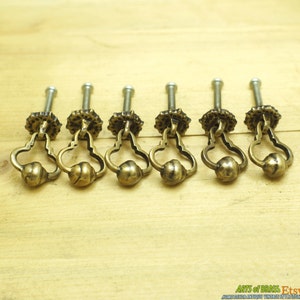 Pode incluir: Seis botões de armário de latão antigo com um design em forma de coração e um botão redondo. Os botões têm um parafuso na parte de trás para instalação.