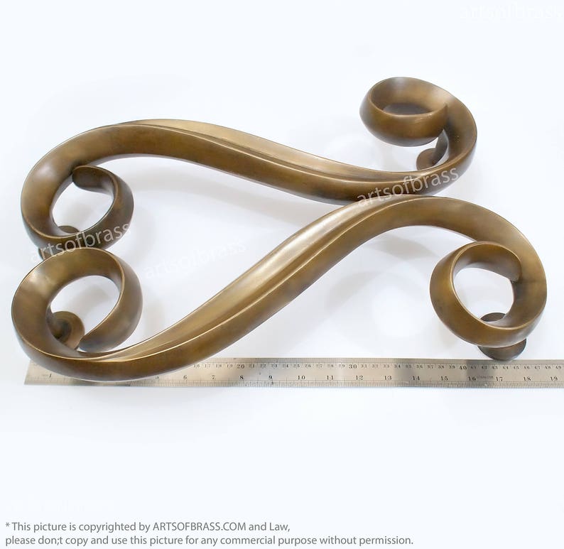 May include: A pair of ornate, gold-toned door handles with a decorative, swirling design. The handles are made of metal and have a polished finish.