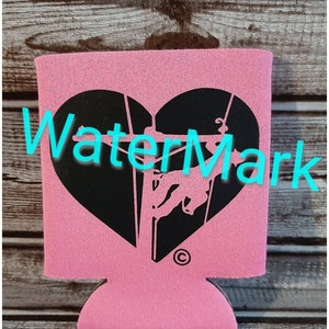 May include: Pink neoprene can cooler with a black heart-shaped design featuring a silhouette of a bull rider. The design includes the text "WaterMark" and a copyright symbol.