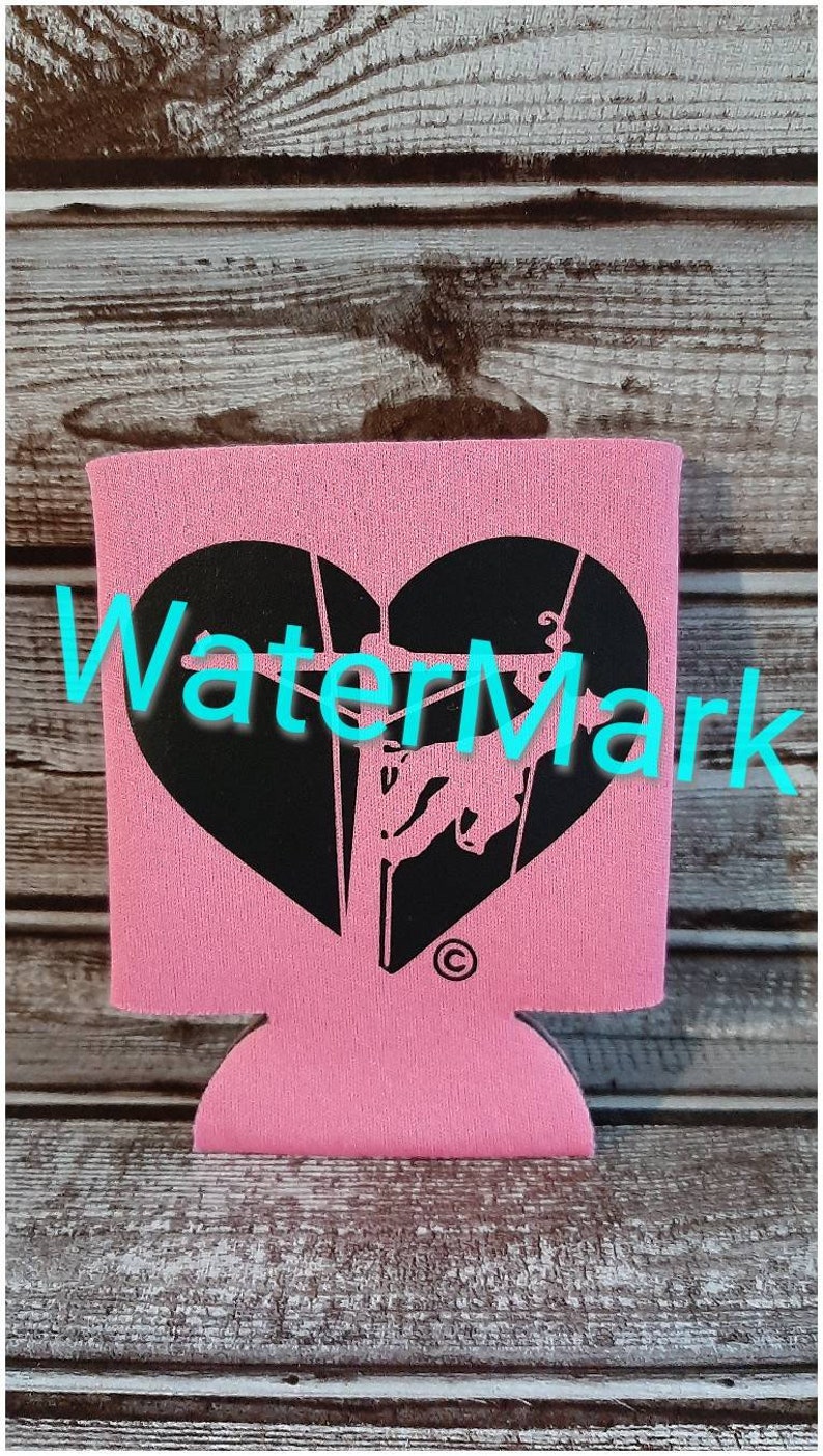 May include: Pink neoprene can cooler with a black heart-shaped design featuring a silhouette of a bull rider. The design includes the text "WaterMark" and a copyright symbol.