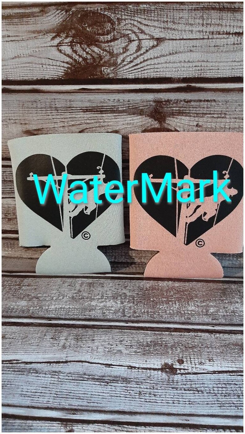 May include: Two insulated beverage holders with a black heart design featuring a silhouette of a person climbing a utility pole. One holder is light blue and the other is pink.