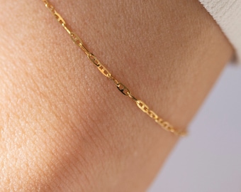 May include: A delicate gold chain bracelet with a simple design.
