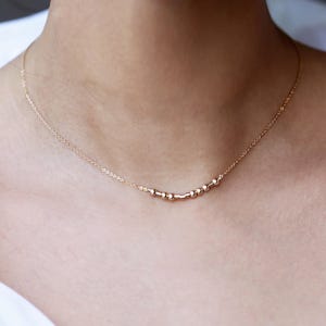 以下が含まれることがあります： 小さな丸いビーズが並んだ、繊細なゴールドネックレス