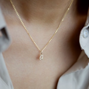 May include: A gold chain necklace with a small, diamond-encrusted letter 'A' pendant.