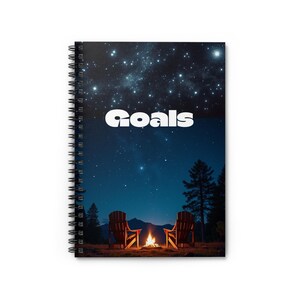May include: Spiral-bound notebook with a night sky design. The top half features a starry sky, while the bottom half shows a campfire scene with two chairs and the word "Goals" in white. The notebook is perfect for journaling or note-taking.