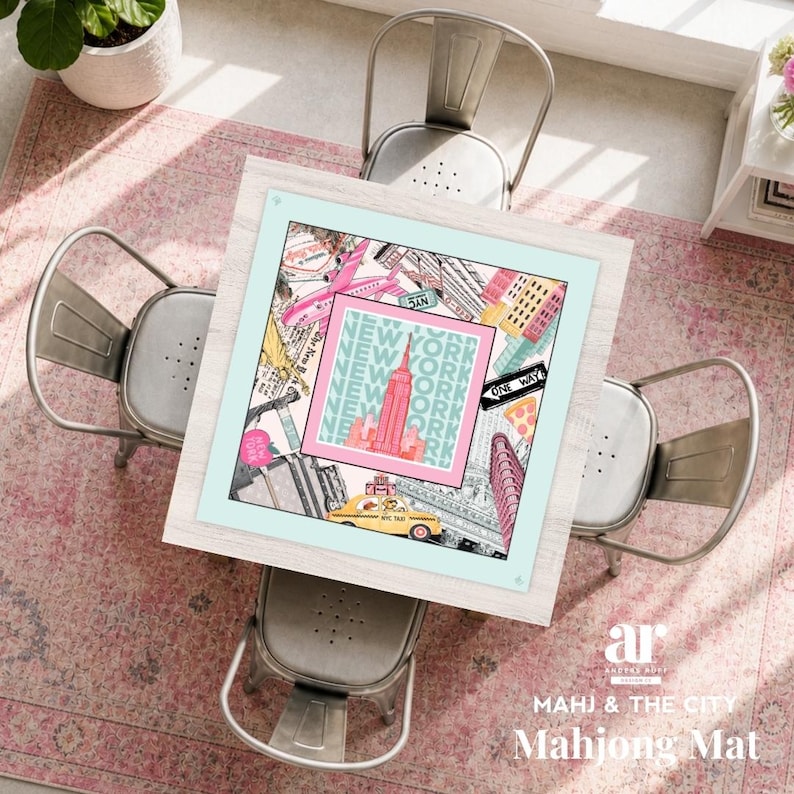 May include: A square mahjong mat with a New York City theme, featuring iconic landmarks like the Empire State Building and a yellow taxi. The mat is framed in light blue and surrounded by four metal chairs and a pink rug. The text "NEW YORK" is repeated on the mat.